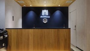 A reception desk with a wooden finish, a neon sign reading "MONDAY," and a door labeled "OFFICE" to the right. - hotel MONday Premium Ueno Okachimachi (Tokyo)
