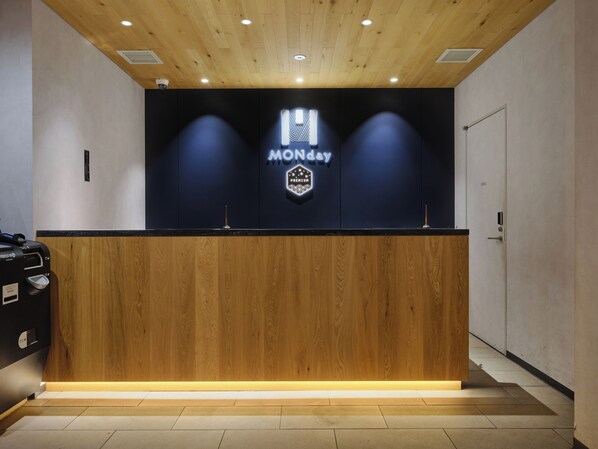 A reception desk with a wooden finish, a neon sign reading "MONDAY," and a door labeled "OFFICE" to the right. - hotel MONday Premium Ueno Okachimachi (Tokyo)