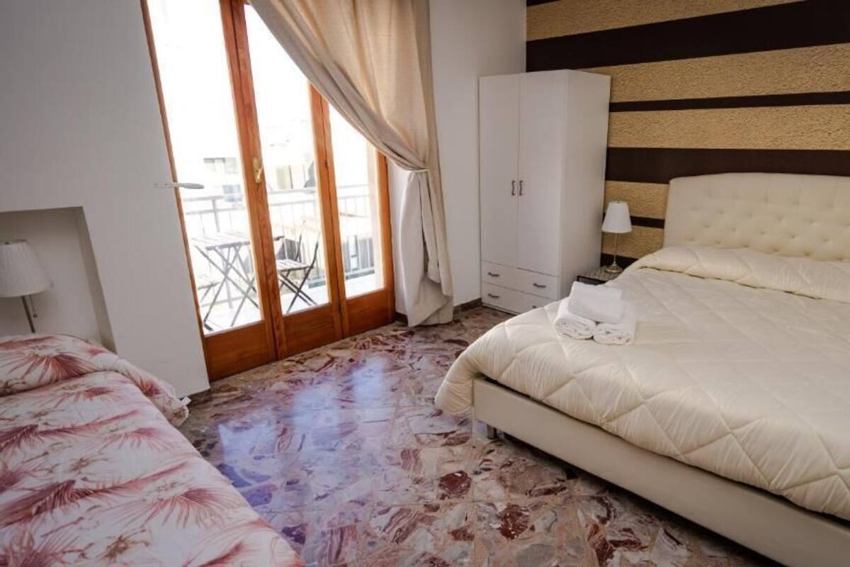 Un dormitorio con una cama grande, un armario y vistas al balcón exterior.