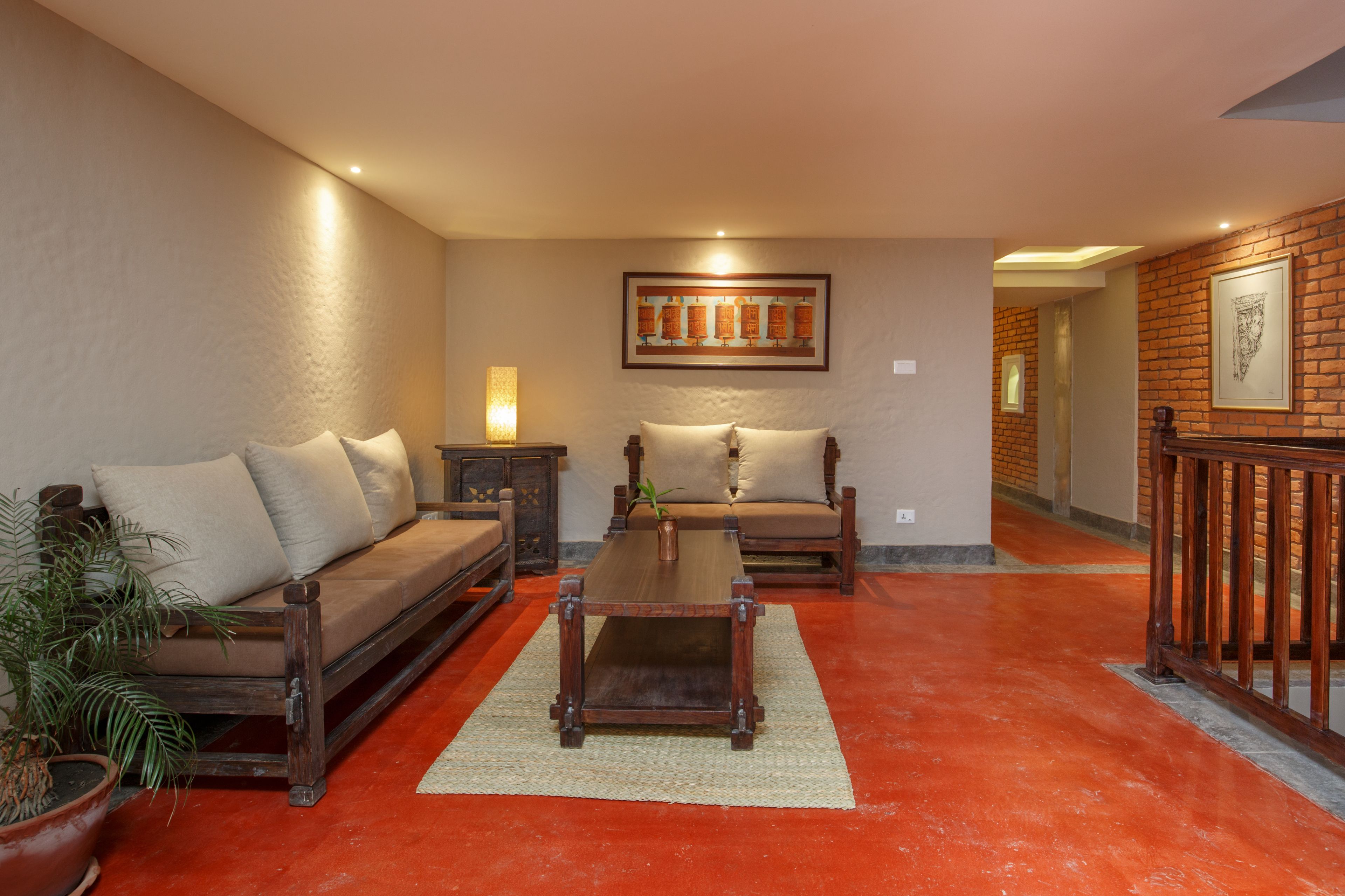 A living room with a sofa, a coffee table, and a potted plant.