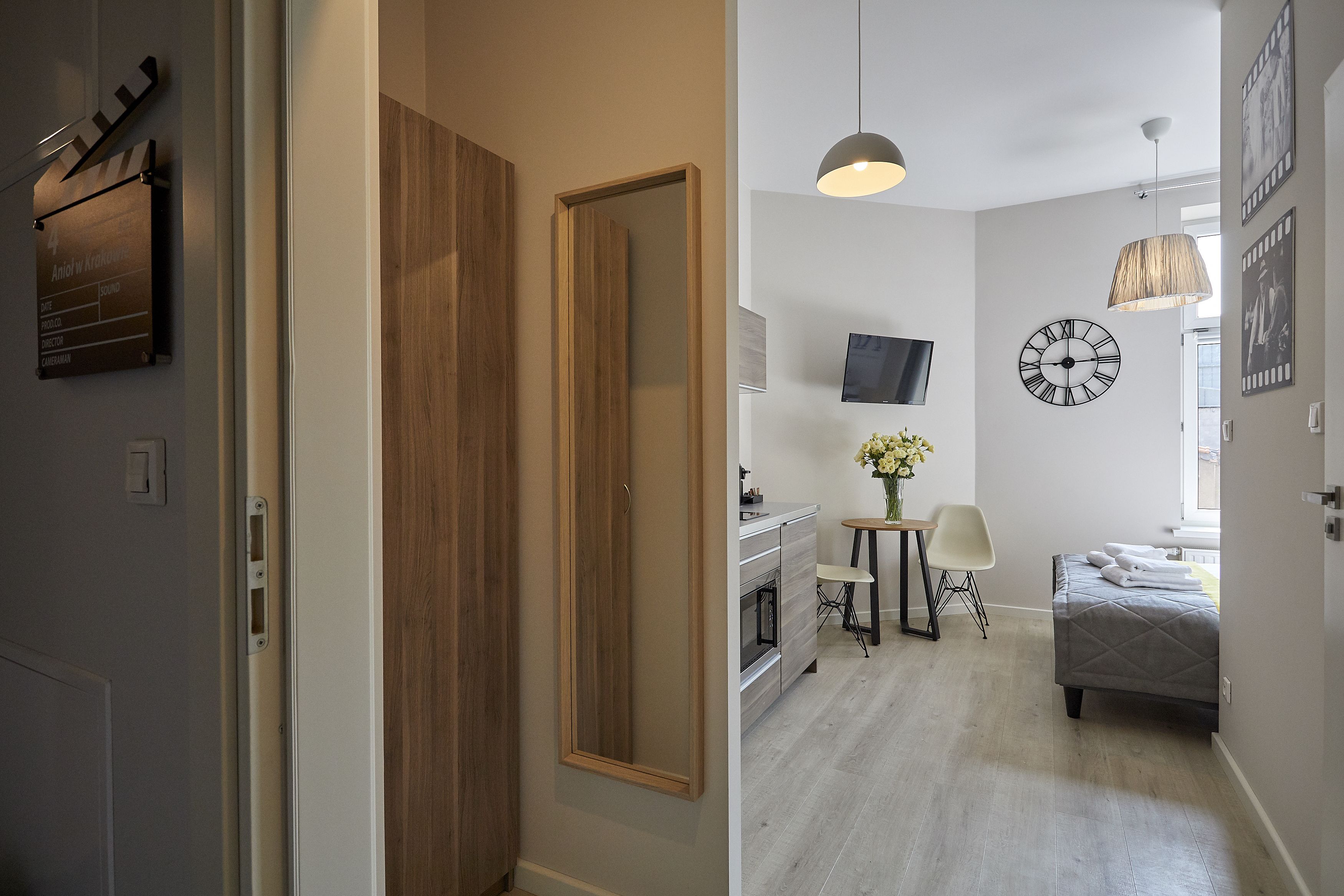 Un interior moderno con una puerta de madera, una kitchenette, una cama y un comedor.