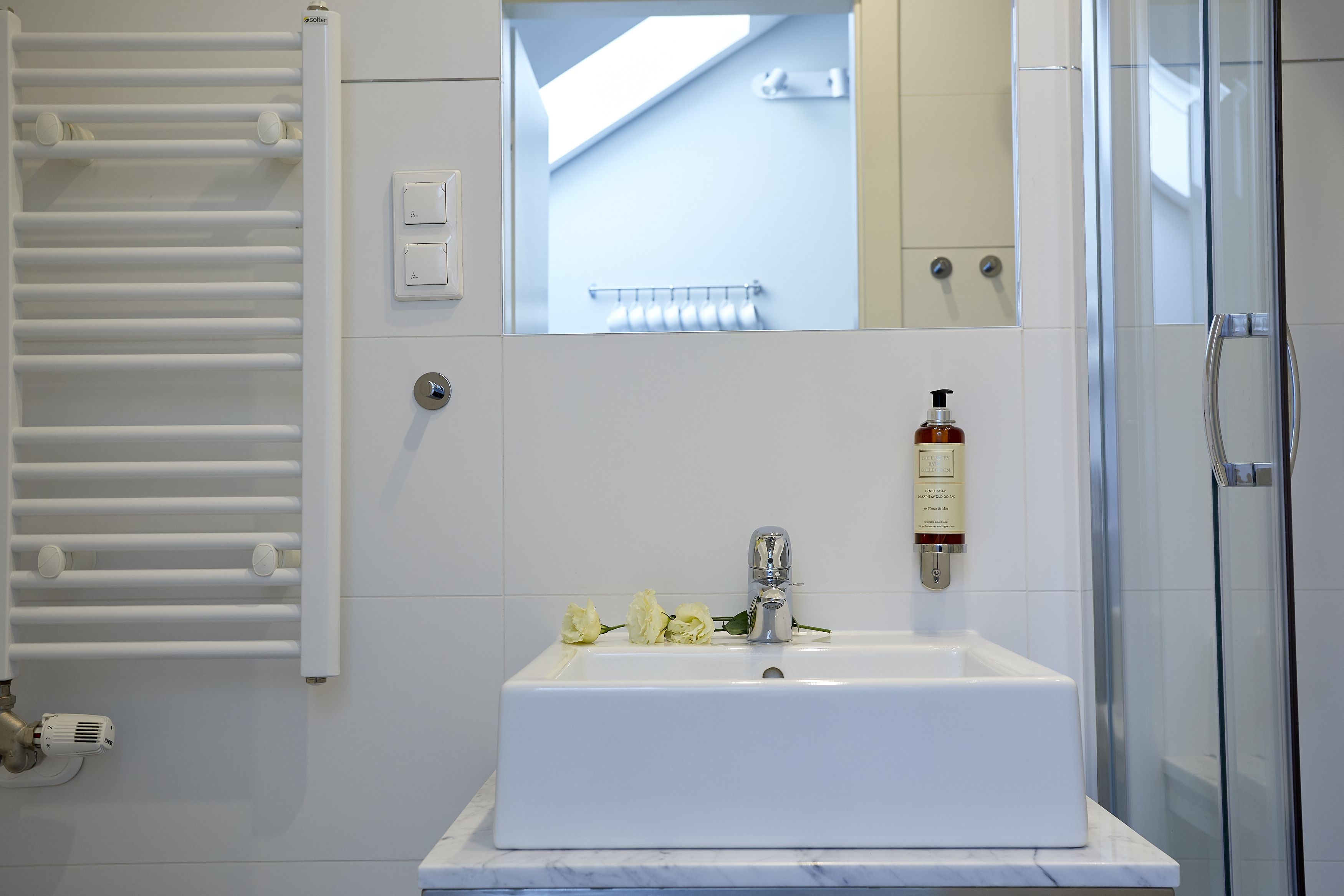 Ein Badezimmer mit Waschbecken, Dusche und Handtuchhalter.