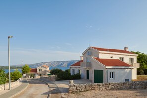 A two-story house with a red-tiled roof, a balcony, and a stone wall in front. - Luxury Villas Stari Grad (Stari Grad)