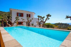 Una villa moderna con piscina, immersa nel verde e con vista panoramica.