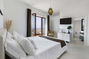 A modern bedroom with a large bed, a dresser, a TV, and a view of the outdoors.