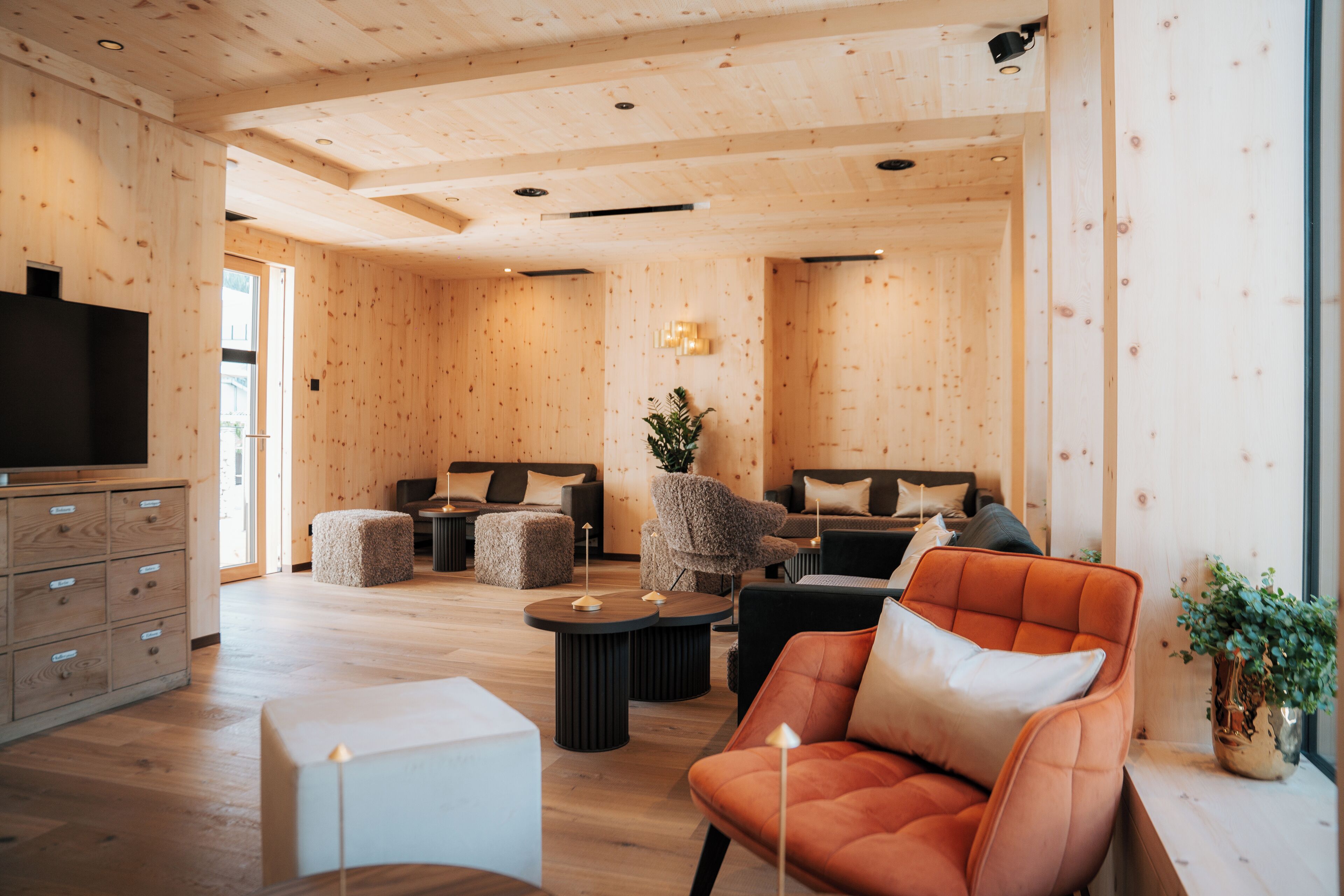 Un salon moderne avec des murs en bois, un téléviseur à écran plat et des sièges confortables.