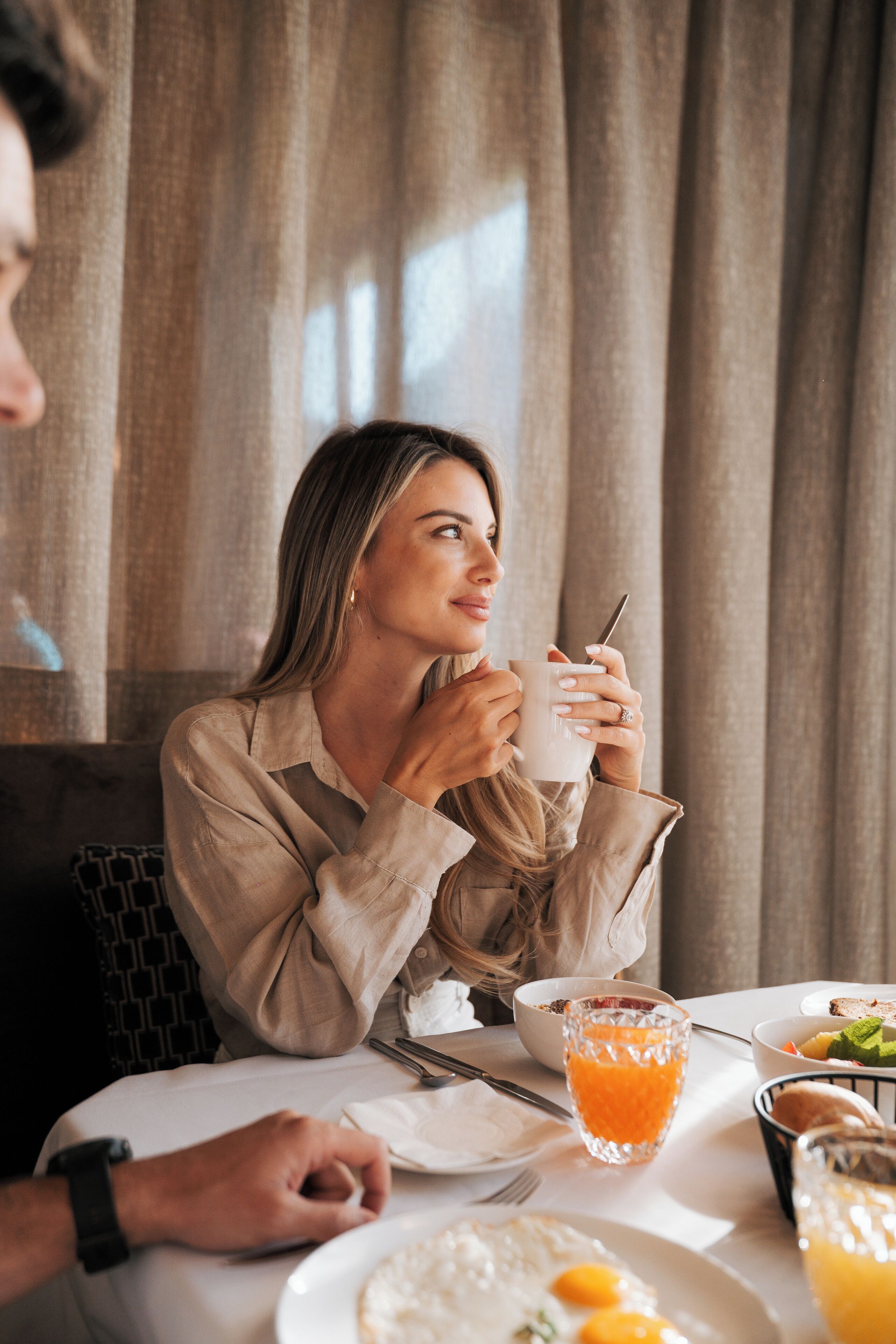 Une table à manger avec des aliments pour le petit-déjeuner, notamment des œufs, des toasts et du jus d’orange.