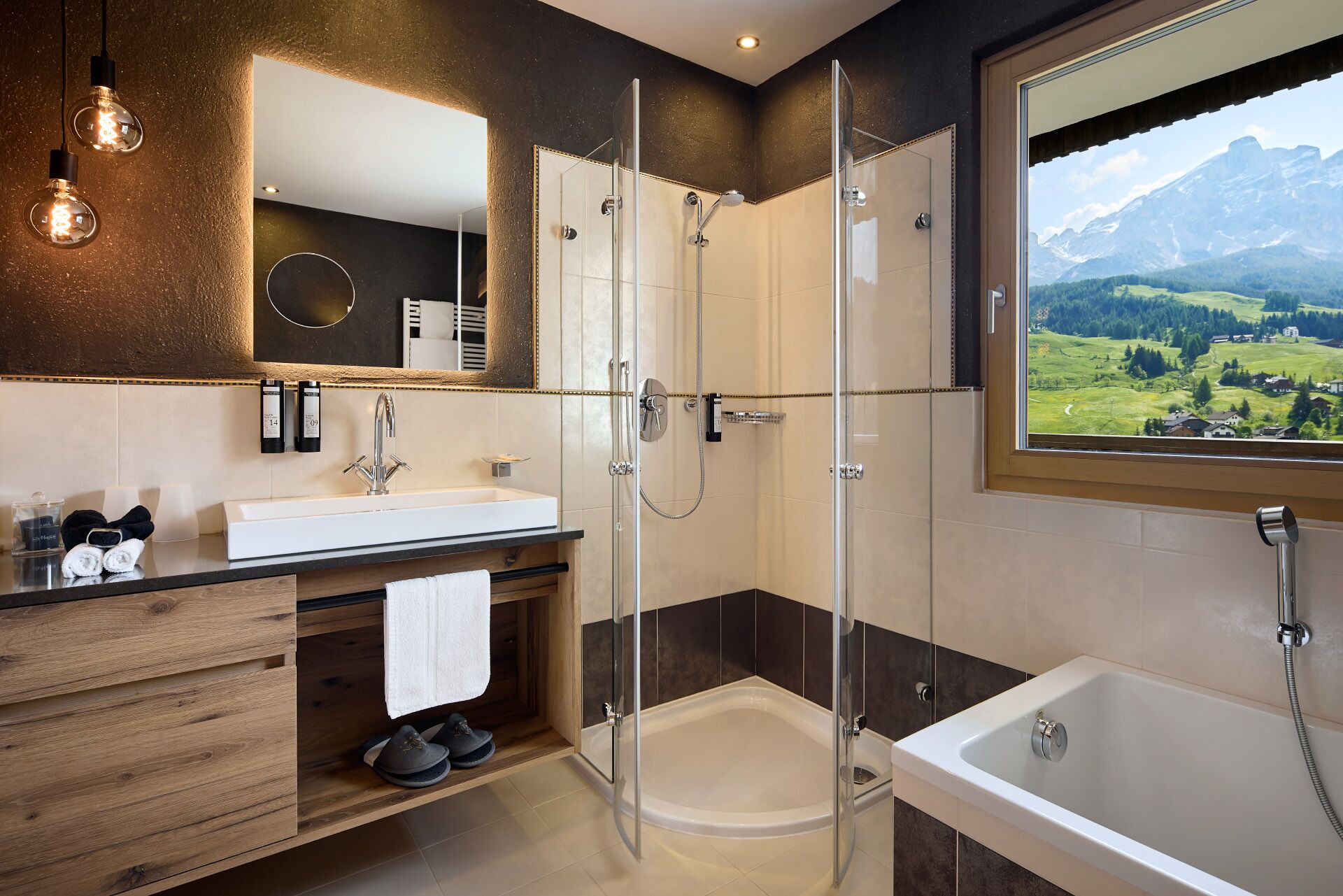 Un baño moderno con ducha de vidrio, bañera y un amplio ventanal con vistas a la montaña.