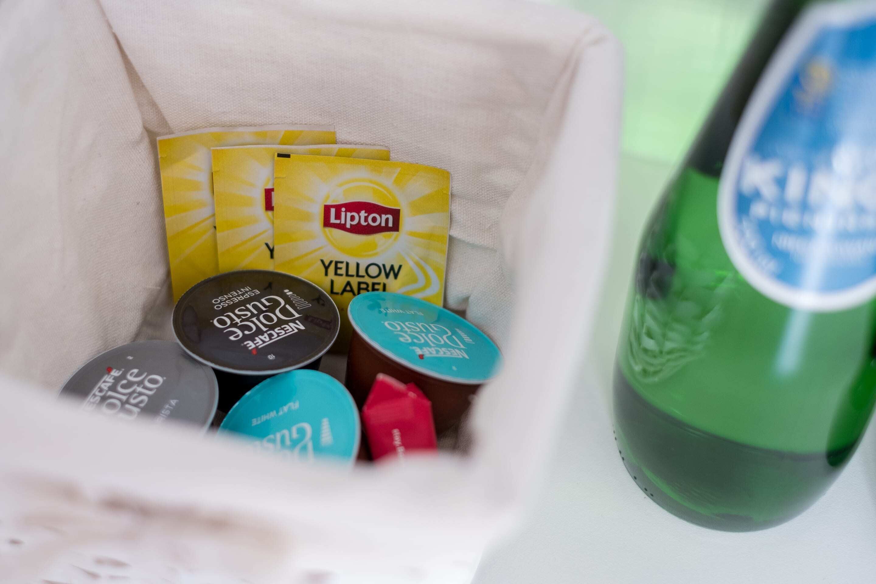 A bag containing Lipton Yellow Label tea bags, a green bottle, and various other items.