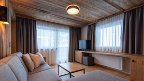 Uma sala de estar moderna com teto de madeira, televisão de tela plana, sofá e mesa de centro.