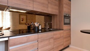 A modern kitchen with wooden cabinets, a stainless steel sink, and a built-in oven.