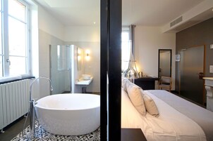 Un baño moderno con una bañera independiente, un lavabo y un espejo.