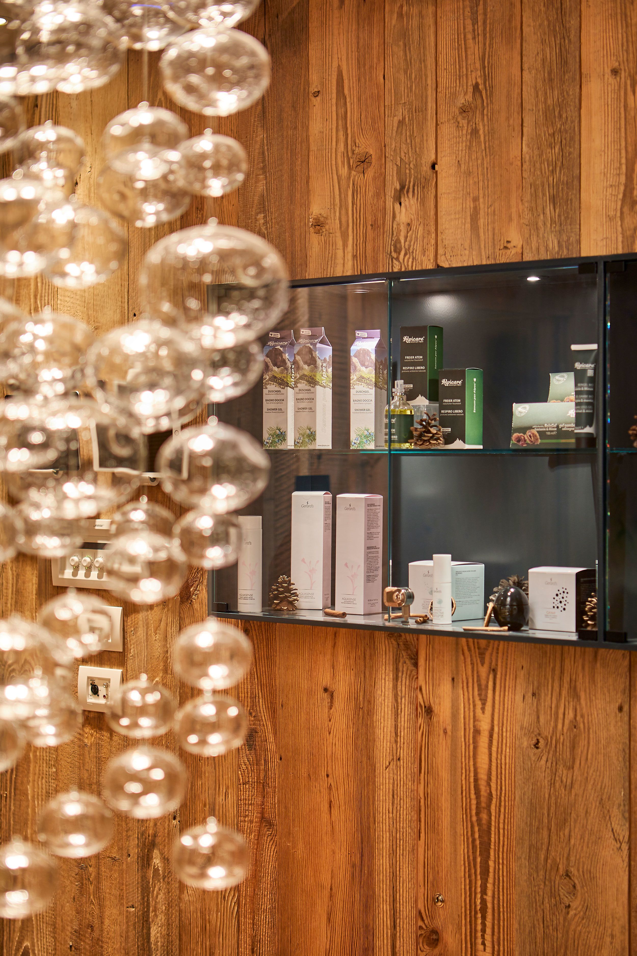 A wooden wall with a glass display case containing various products.