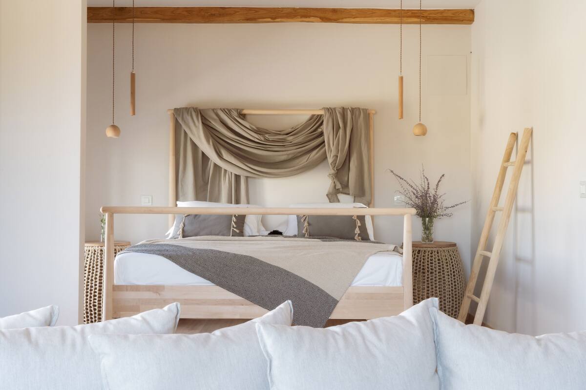 A minimalist bedroom with a wooden bed frame, a neutral color palette, and a simple decor.