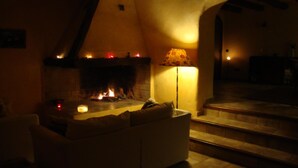 Una sala de estar acogedora con chimenea, un sofá y una lámpara.
