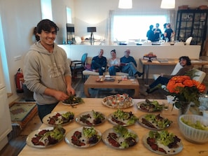 Un espace repas avec plusieurs tables dressées pour le repas, entouré de canapés et de fauteuils.