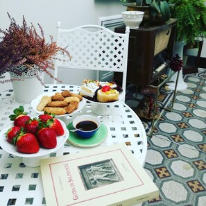A table with a book, strawberries, cookies, and a dessert. - Palazzo al Carmine Dimora Storica (Castelvetrano)