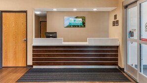 A reception area with a wooden door, a reception desk, a sign reading "Welcome to Illinois," and a "Stand Clear" sign near the door. - Comfort Inn & Suites near Route 66 (Lincoln)