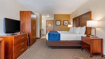 A hotel room with a bed, a TV, a desk, and a wardrobe.