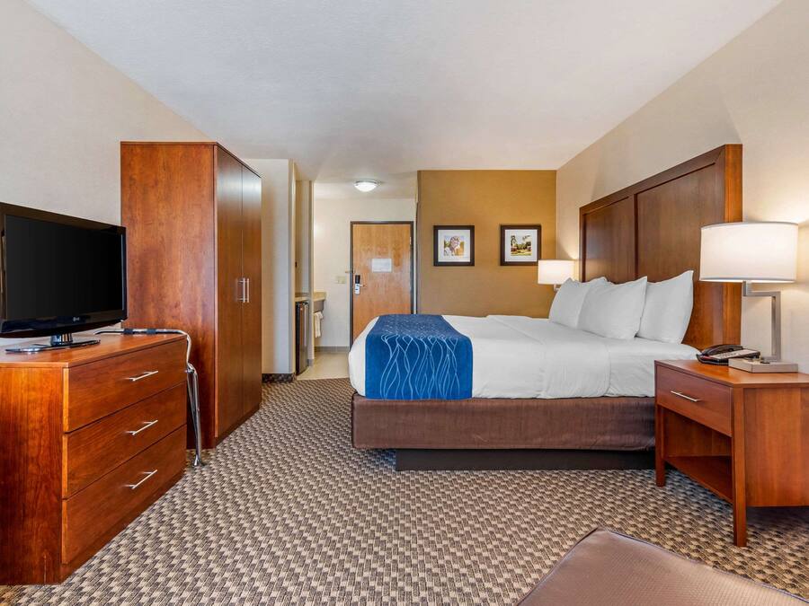 A hotel room with a bed, a TV, a desk, and a wardrobe.