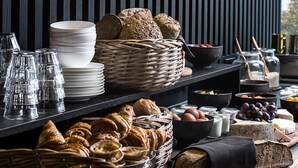 Een ontbijtbuffet met brood, gebak en zuivere melkproducten.