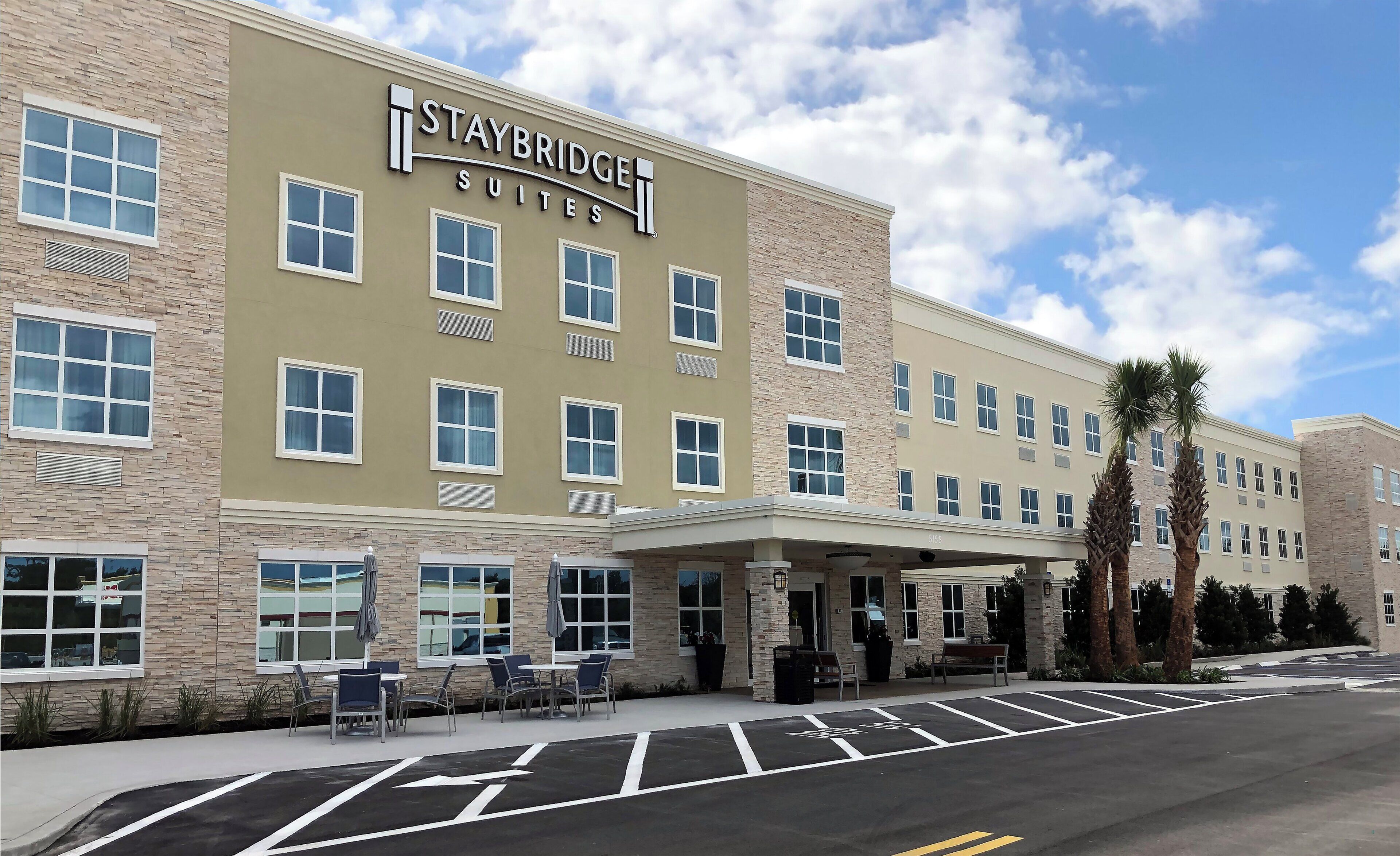 A Staybridge Suites hotel with a brick facade, multiple windows, and a covered entrance area.