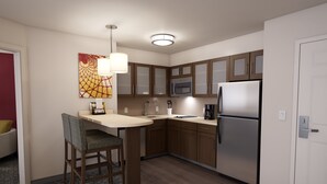 Een moderne keuken met houten kastjes, een roestvrijstalen koelkast en een barstoel.