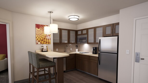 Una cocina moderna con armarios de madera, un refrigerador de acero inoxidable y un taburete de bar.