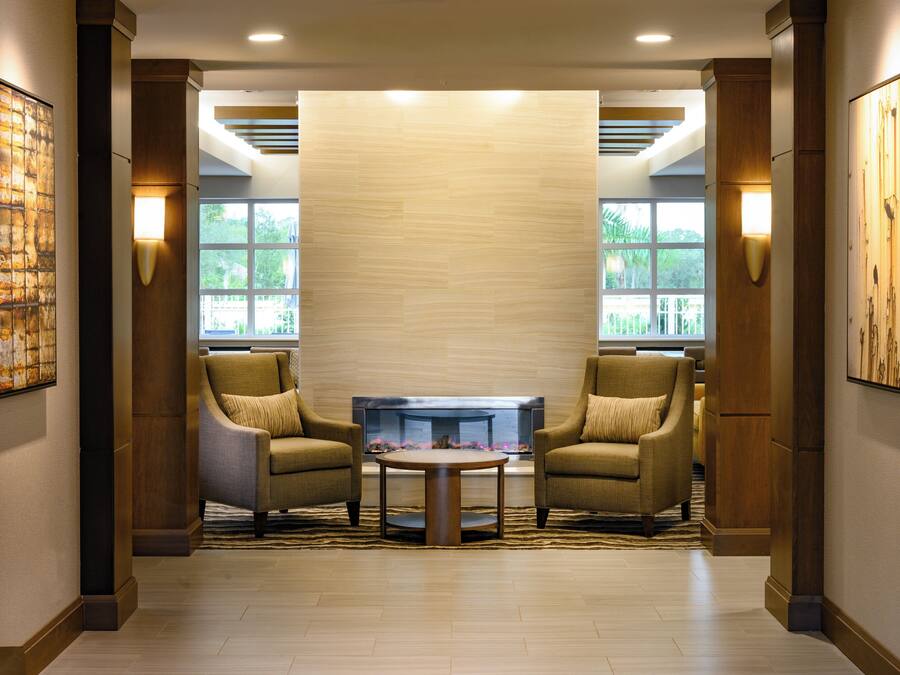 A lobby with two armchairs, a coffee table, and a fireplace.