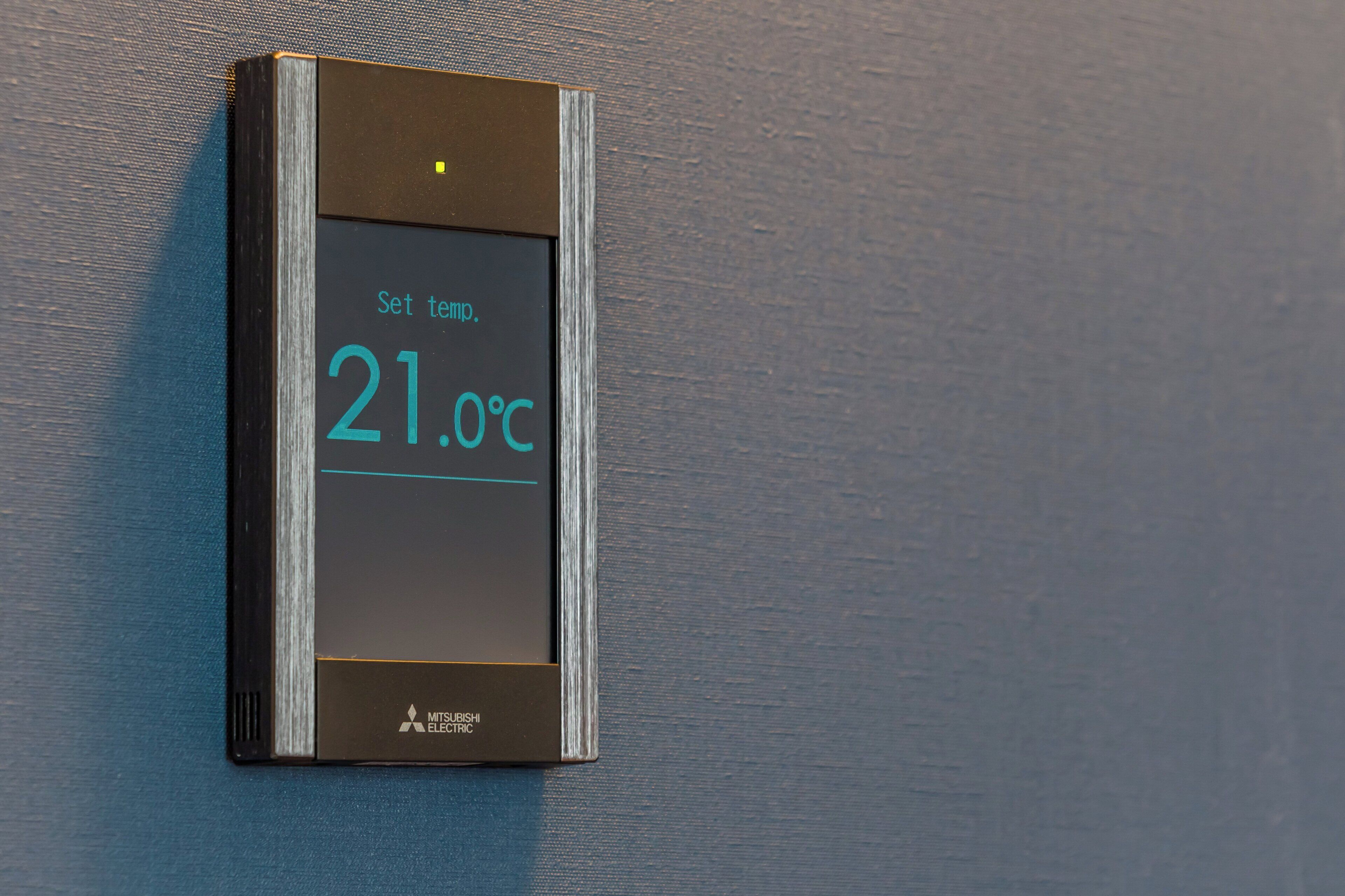 A digital thermostat displaying a temperature of 21.0°C.