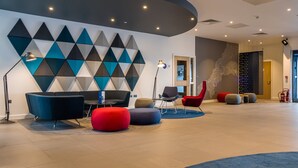 A modern lounge area with geometric wall art, contemporary seating, and a clean, well-lit space. - Holiday Inn Express Bodmin - Victoria Junction by IHG (St Austell)