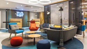 A modern hotel lobby with a reception desk, seating area, and decorative lighting. - Holiday Inn Express Bodmin - Victoria Junction by IHG (St Austell)