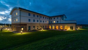 A modern hotel with multiple floors, outdoor seating, and well-lit pathways. - Holiday Inn Express Bodmin - Victoria Junction by IHG (St Austell)