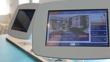 Dos quioscos digitales con pantallas mostrando información y opciones de hotel.