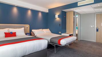 A hotel room with two beds, a desk, a chair, and a wardrobe.