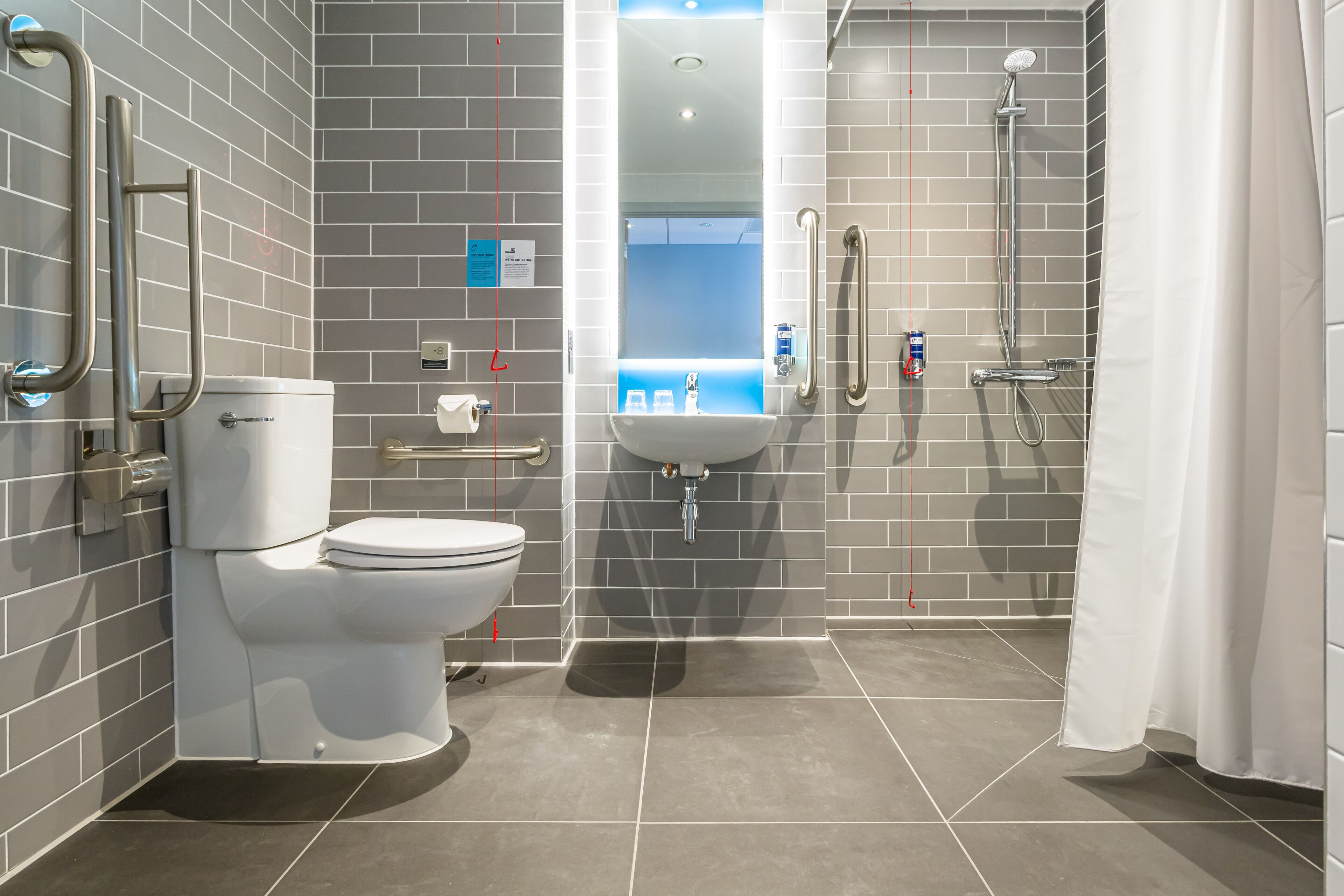 A modern bathroom with a toilet, sink, and shower.