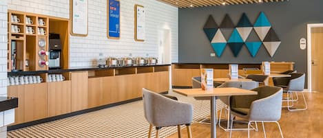 A modern cafe with a checkered floor, wooden counter, and seating area.