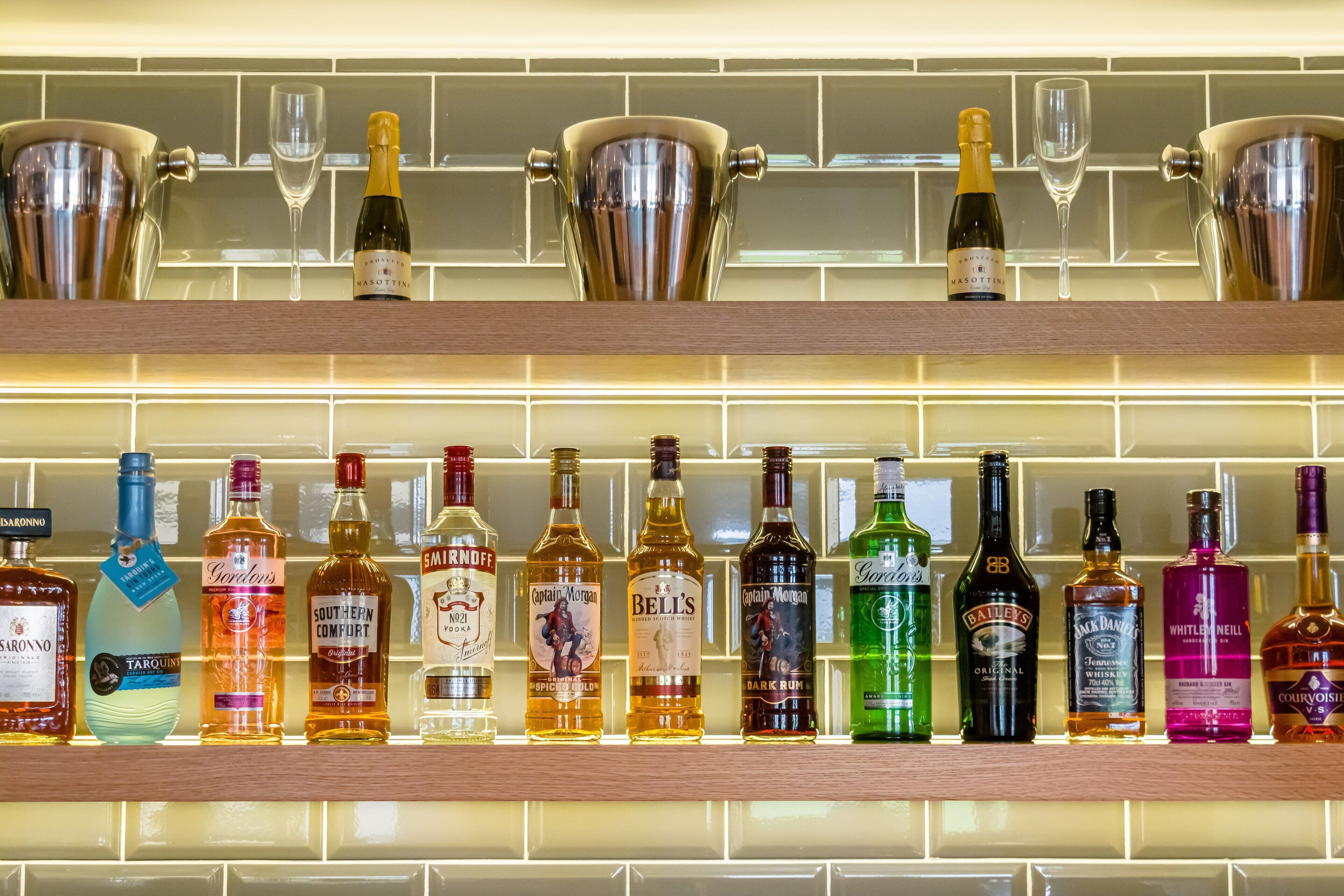 A bar area with multiple shelves of liquor bottles and glasses.