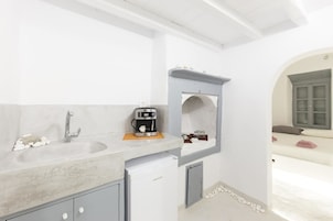 A bathroom with a sink, coffee machine, and a mirror.