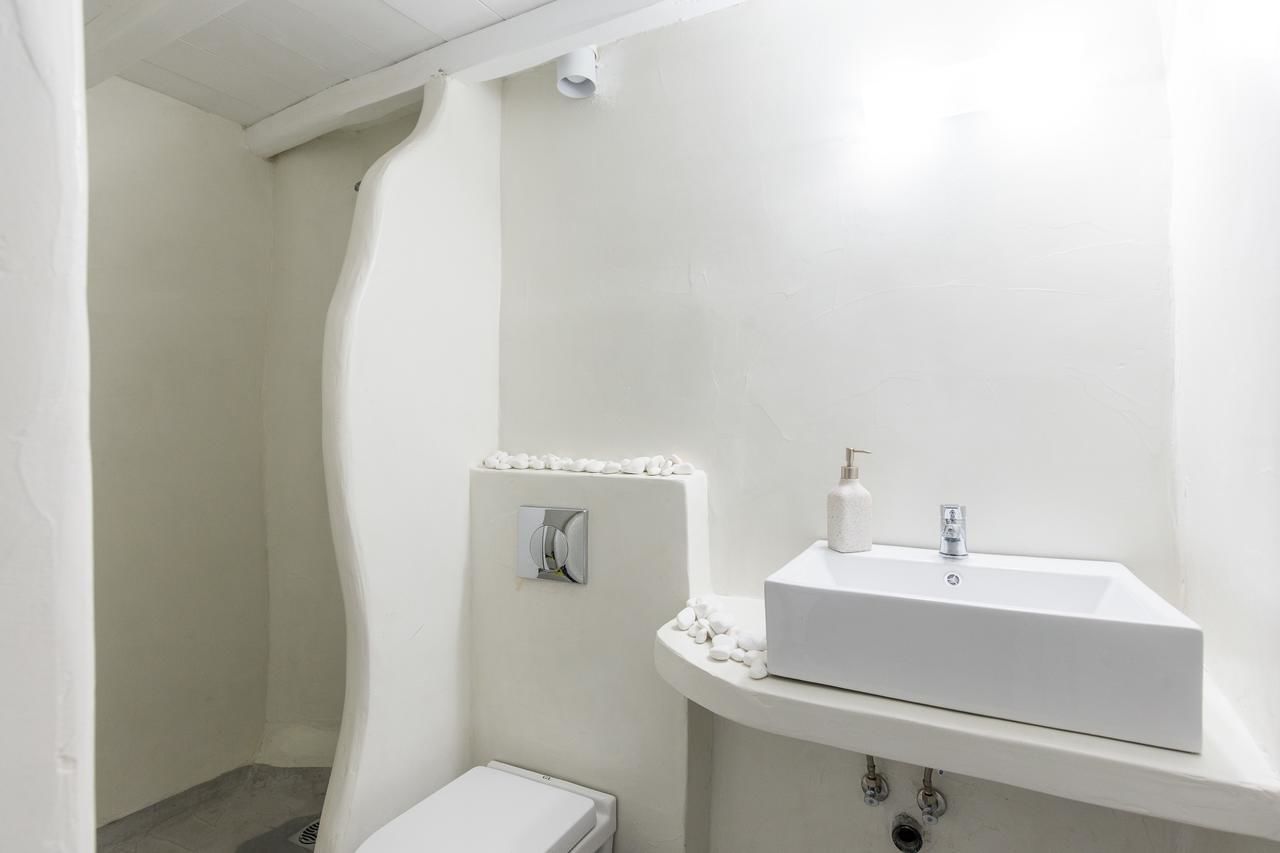 Et badeværelse med hvid vask, toilet og brusebad.