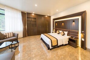 A modern hotel room with a large bed, a sofa, a desk, and a wardrobe. - CoTo Starlight Boutique Hotel (Co To)