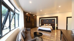 Una camera da letto moderna con un letto grande, una poltrona, un tavolino e una scrivania.