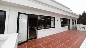 Un edificio moderno con ampie finestre e un patio piastrellato.
