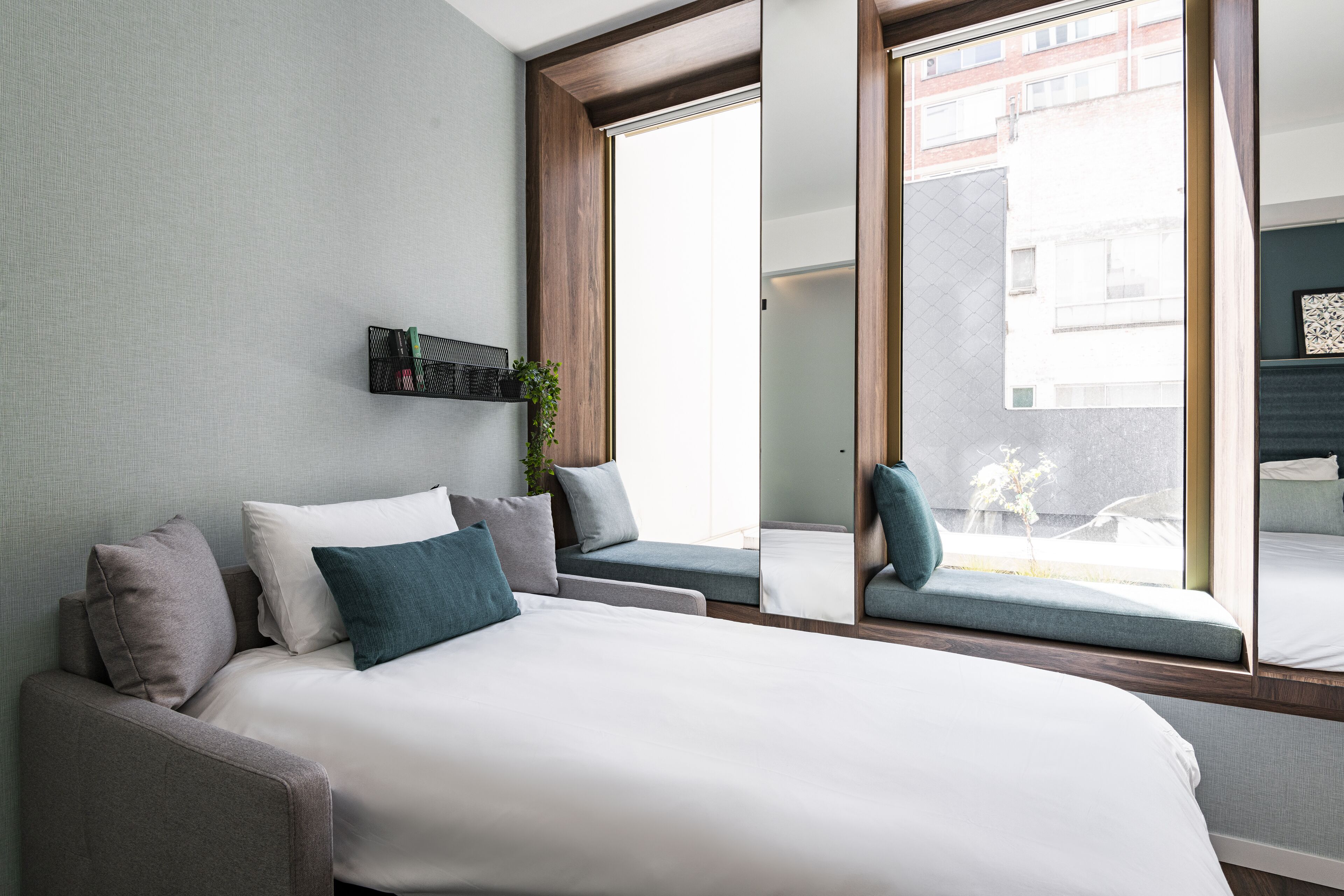 Een moderne slaapkamer met een groot bed, een sofa en een vensterbank.
