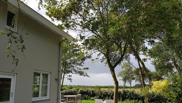 A house with a patio area, a lawn, and a view of the countryside. - De Haas (Oostkapelle)
