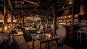 An outdoor dining area with wooden furniture and a bar.