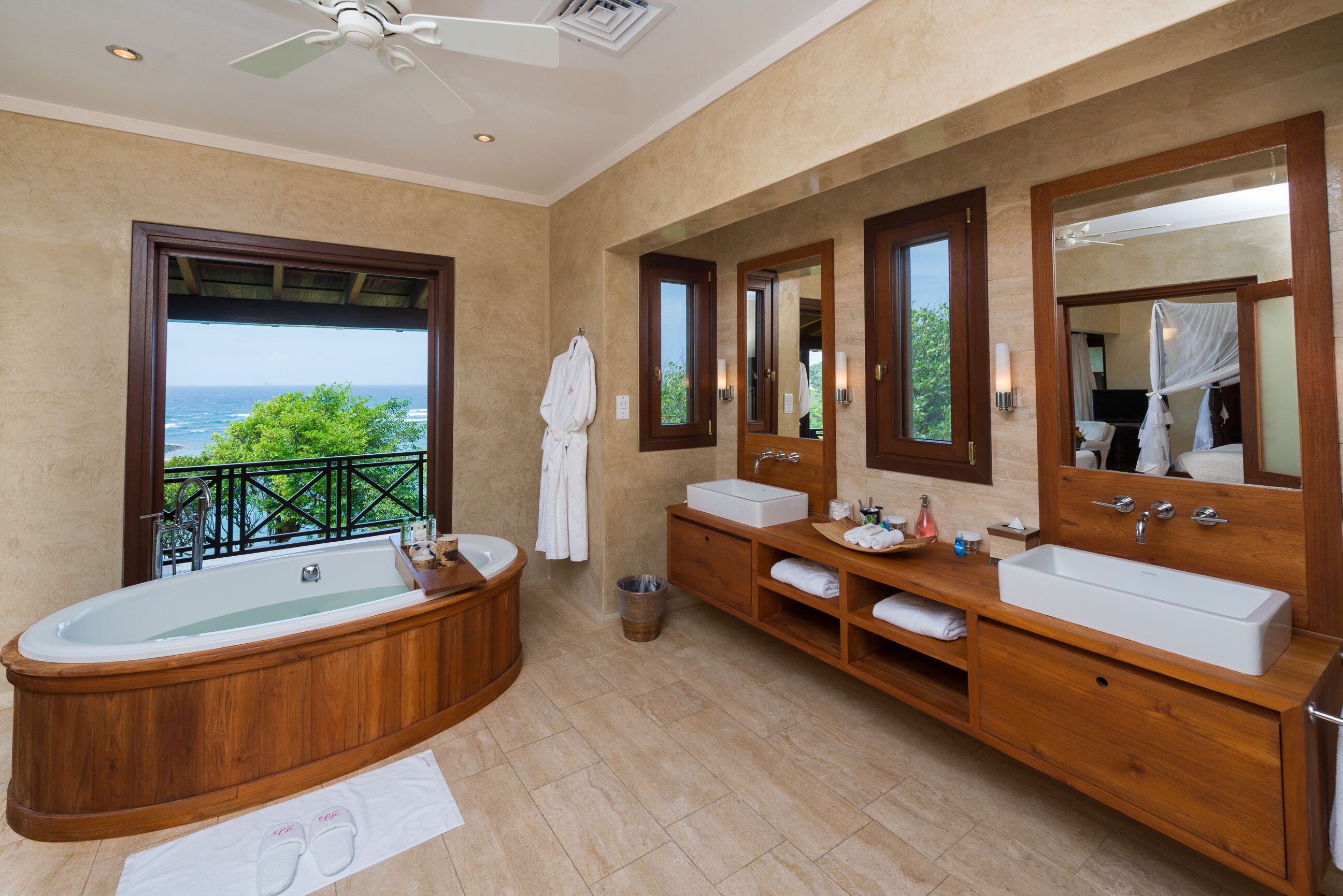 A spacious bathroom with a large bathtub, two sinks, and a large mirror.