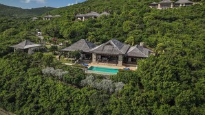 A resort with multiple buildings surrounded by lush greenery and hills.