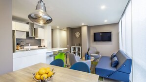 A modern living space with a dining area, kitchen, and seating area. - Apartamentos Facile (Bogotá)