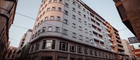 A multi-story hotel with a curved facade, large windows, and balconies.